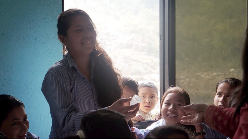A workshop participant explains to her class mates how to fold a Ruby Cup! — at Makwanpur District Nepal.